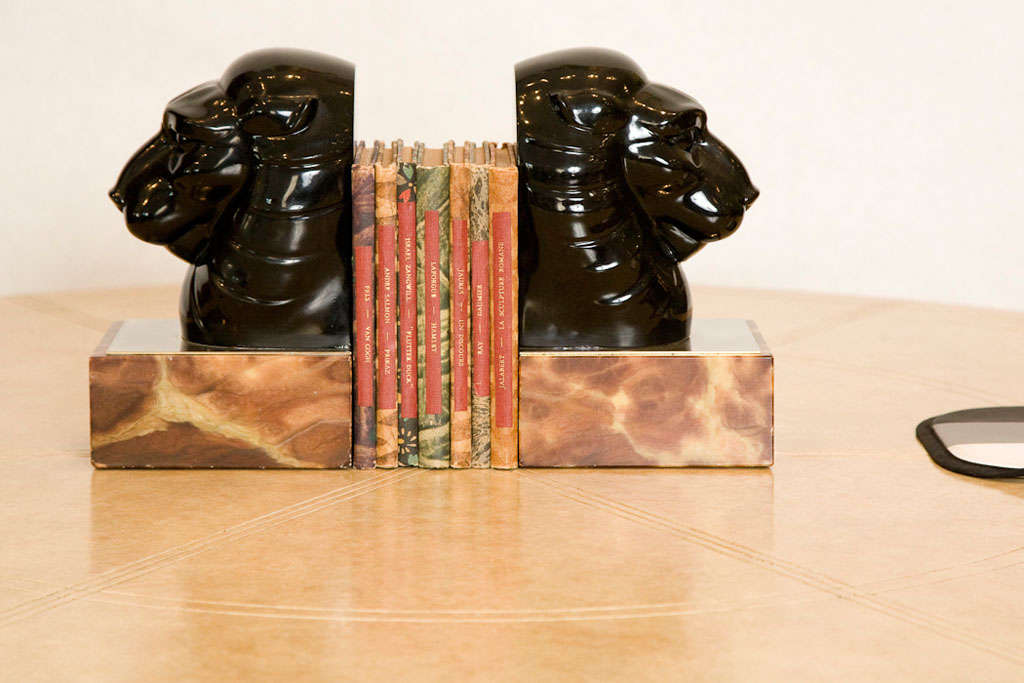 A chic stylized pair of vintage Art Deco style lion head bookends.  These are comprised of black molded resin, nickel plated metal and brown marble.