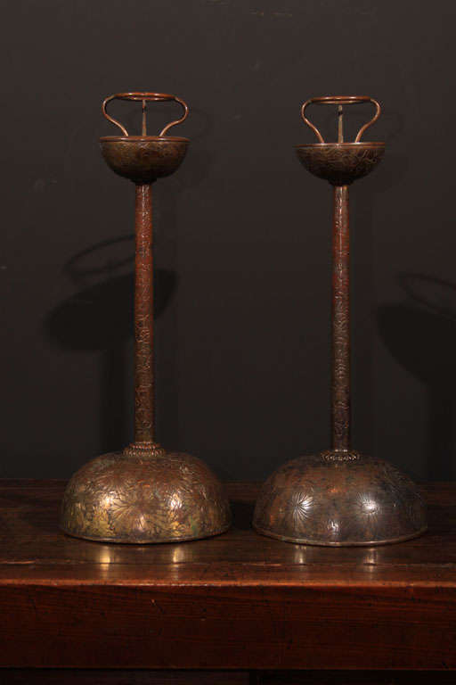 A pair of Japanese gilt copper candlesticks (shokudai) with intricate overall chased and repousse chrysanthemum design. One candlestick with gilded surface, the other with silvered surface. The domed bases with double layered chrysanthemum surrounds