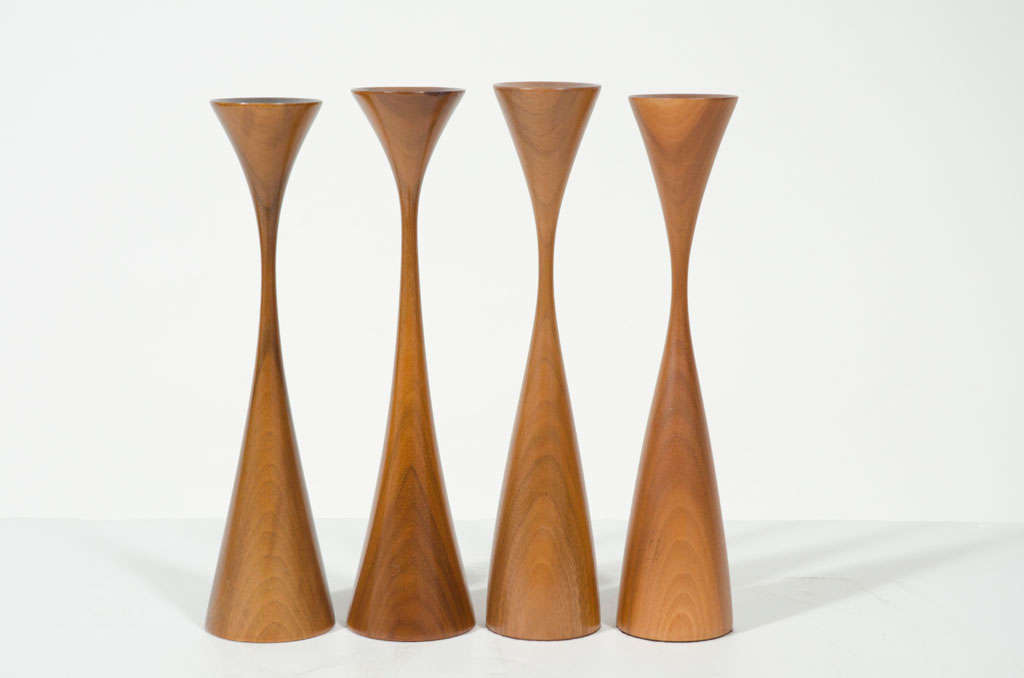 A sculptural set of two candlesticks hand-turned in walnut; each in an elongated hourglass form, one slightly shorter than the other. Rude Osolnik's pieces are part of permanent collections at distinguished museums such as the Boston Museum of Fine