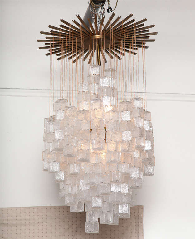 EXCITING LARGE CHANDELIER MADE IN VENICE 1960'S BY MAZZEGA, THE BLOWN GLASS DROPS ARE DONE IN A REGATO TECHNIC TO RESEMBLE ICE HANGING FROM CHAIN FIXED TO A WONDERFUL BRASS CANAPE.