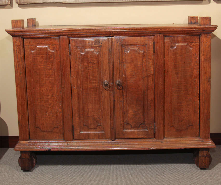 A large wheeled kitchen cabinet (lemari roda) from Central Java, Indonesia. Constructed of solid teak, the front of the chest with two hinged doors, the interior with central shelf above a storage space with two sliding doors.<br />
A rare