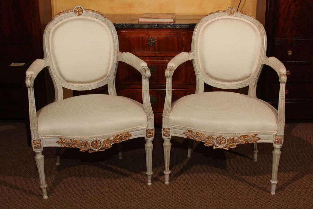 Pair of French Louis XVI Arm Chairs

These are a pair of painted, oval back Louis XVI arm chairs with upholstered arm rests, backs and seat.

They are a nice pair of large sized armchairs and feature white Scalamandre fabric.  

The grey paint