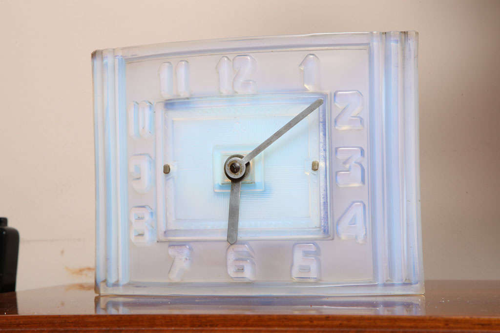 A curved Art Deco mantel clock by Léon Hatot (ATO).

No. 78289, made circa 1935.

In opalescent glass with raised Art Deco numerals, inner minute track and baton hands.

measures: Width 9" x height 7" x depth 3".