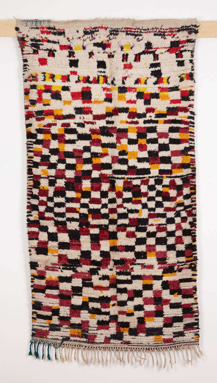 Many of the patterns we see on Berber rugs were woven from memory in a colour scheme which is typical for specific groups. This Azilal rug is decorated by a abstract version of the checkerboard pattern, where the repeat is executed in four colours