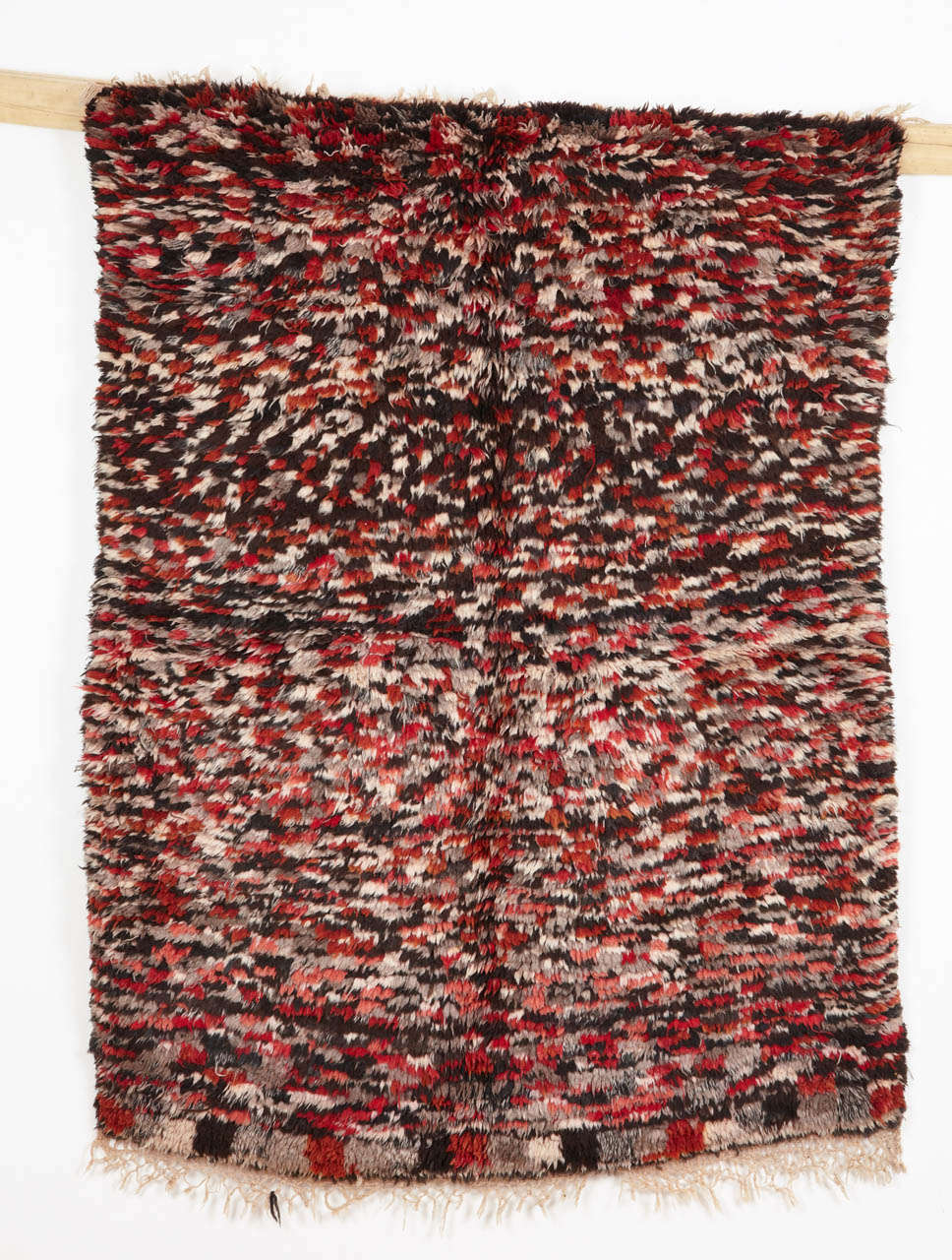 Azilal weavings are often distinguished by a floppy handle and by a relatively thick pile height. This example shows a very dense rendition of the checkerboard pattern, executed in shades of ivory, grey, black and red.