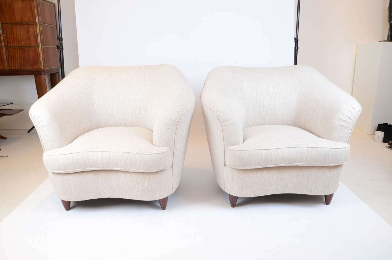 Pair of large upholstered armchairs with walnut legs designed by Gio Ponti. Re upholstered in linen.