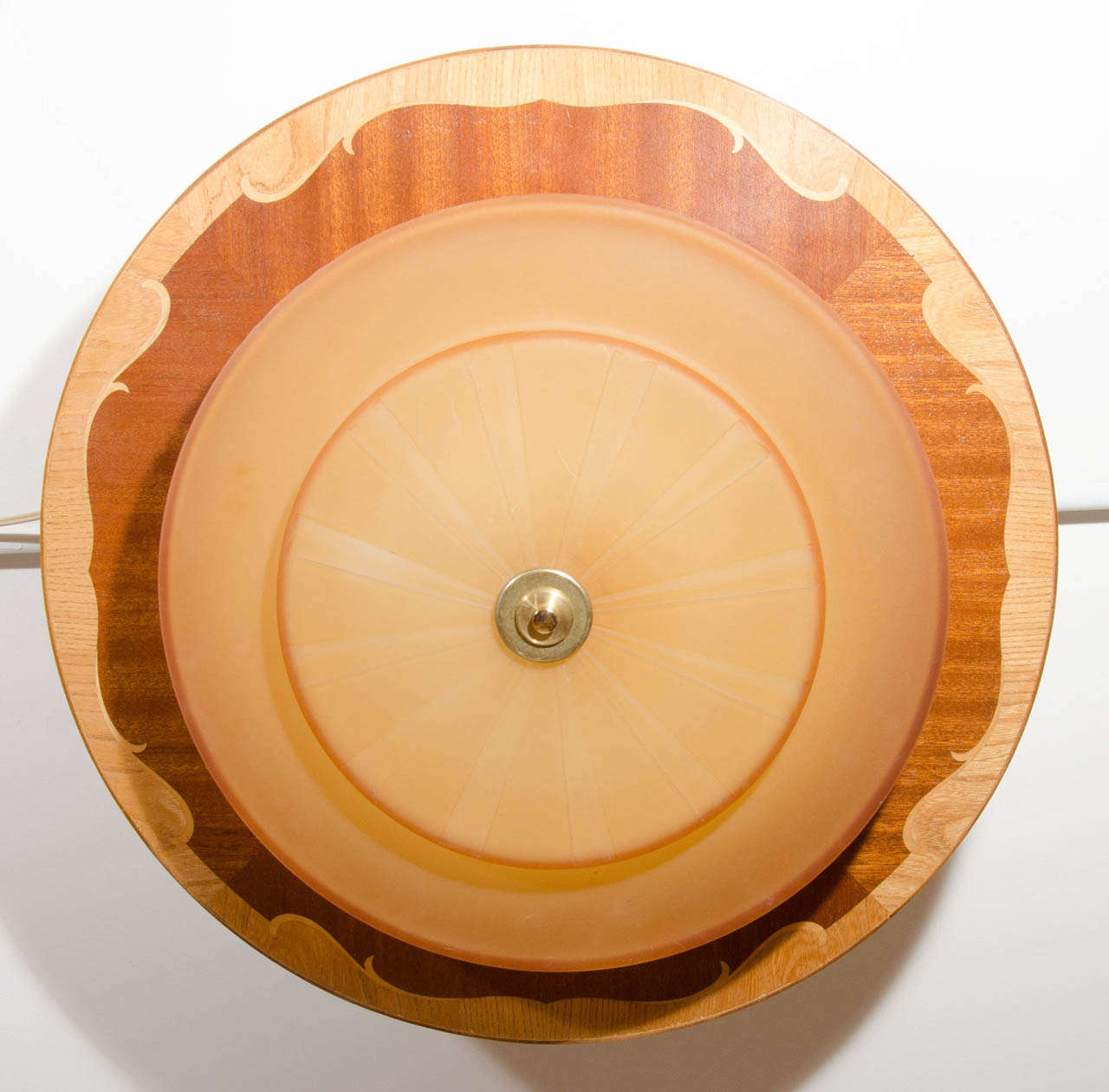Flush mounted, this light features a stepped, frosted and etched golden-toned glass shade protruding from a Mjolby Intarsia disc, artistically inlaid with mahogany, birch and ash veneers.