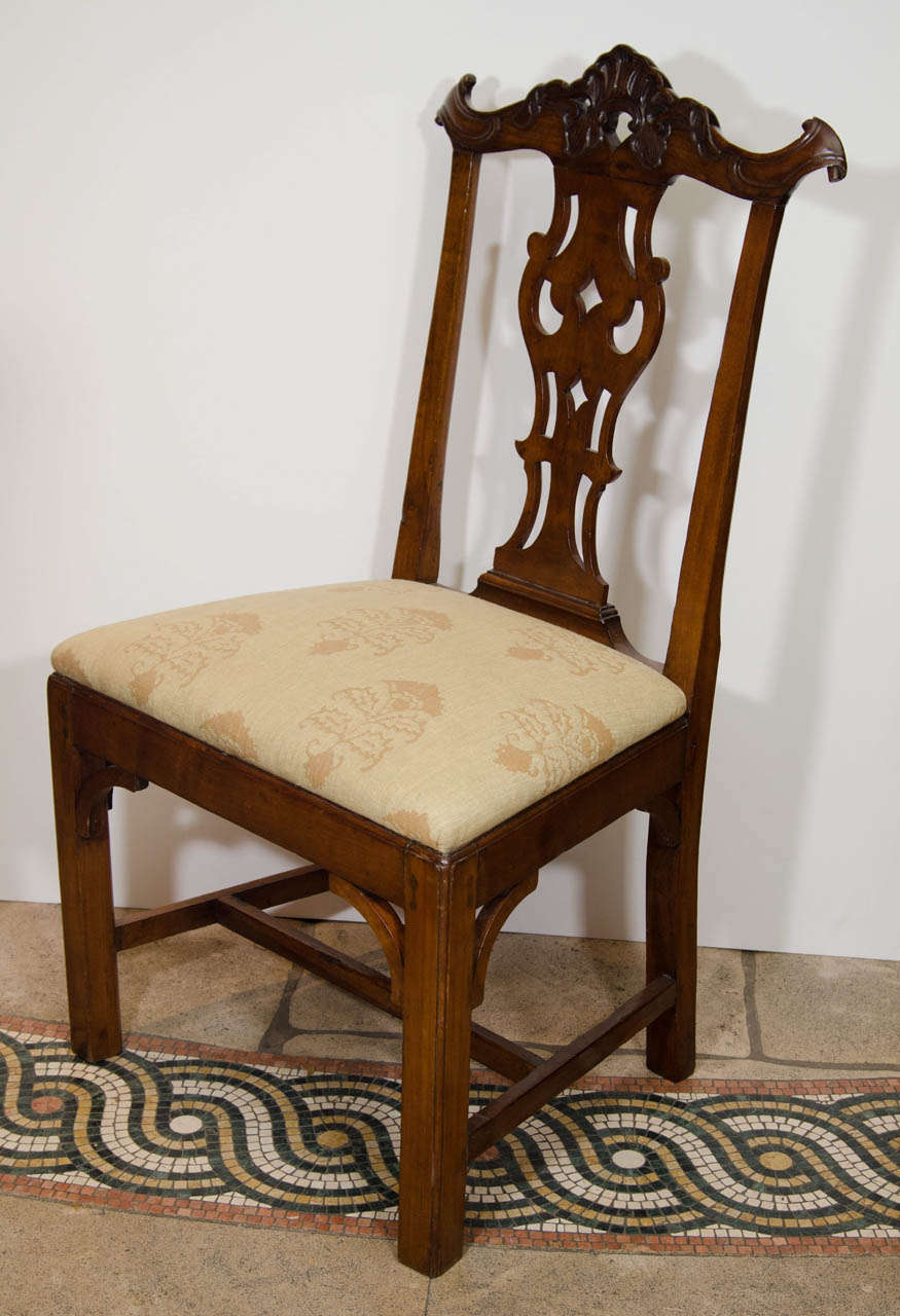 A pair of Portuguese colonial carved mahogany side chairs in the Chippendale manner with pierced cartouche crestrails, drop-in seats and square legs joined by an H-stretcher.