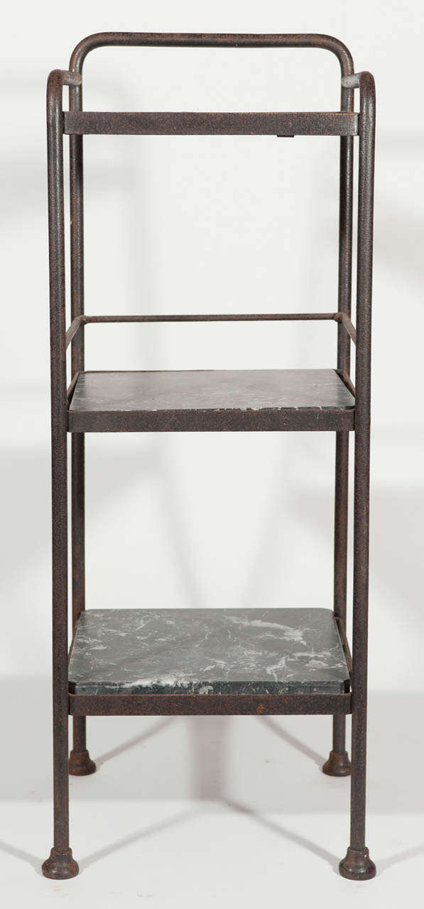 Patinated three-tier metal stand with matte grey veined marble shelves.