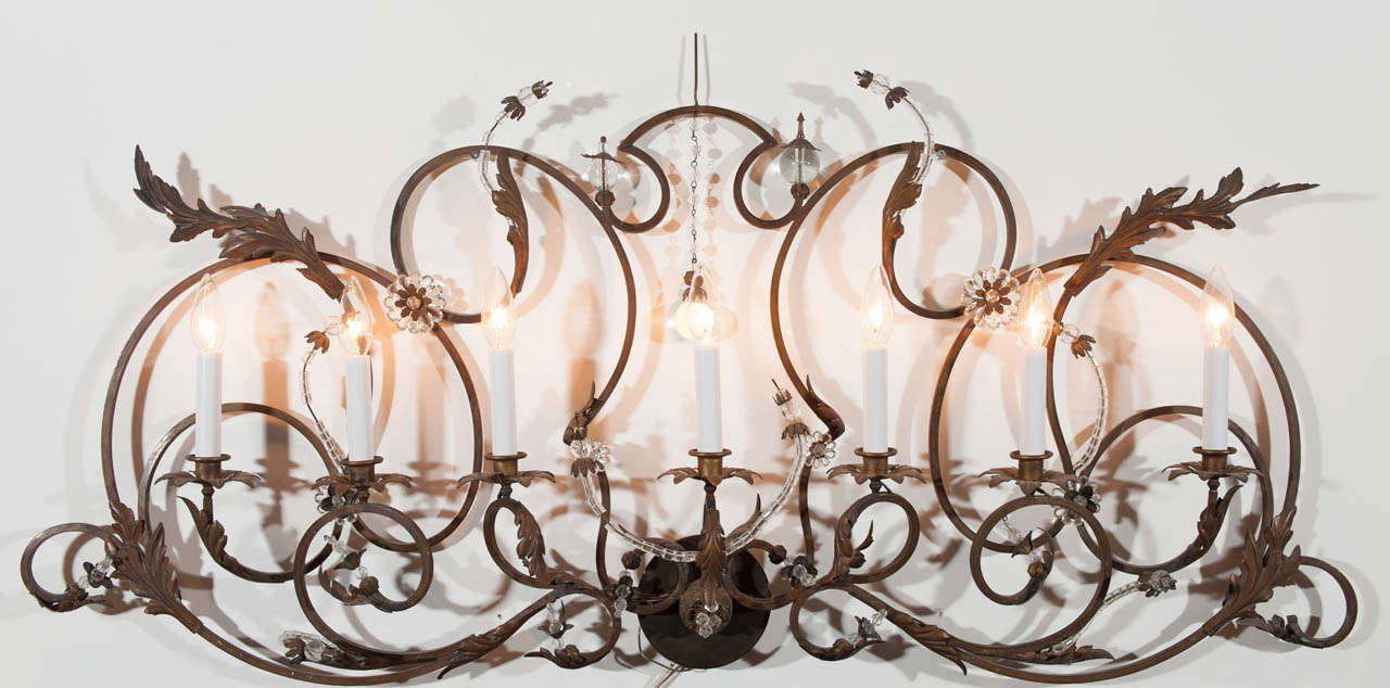 Large wrought iron French Louis XVI style over mantle sconce with decorative faceted and non-faceted crystal detail.