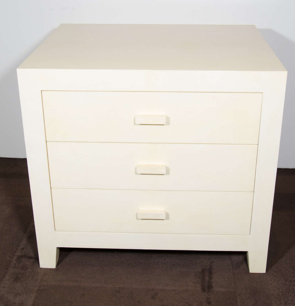 Pair of Ivory Parchment End Tables/ Night Stands with Modern Cube Design with Tapered Legs Detail and Fitted with 3 Drawers. The night stands have walnut wood interiors.