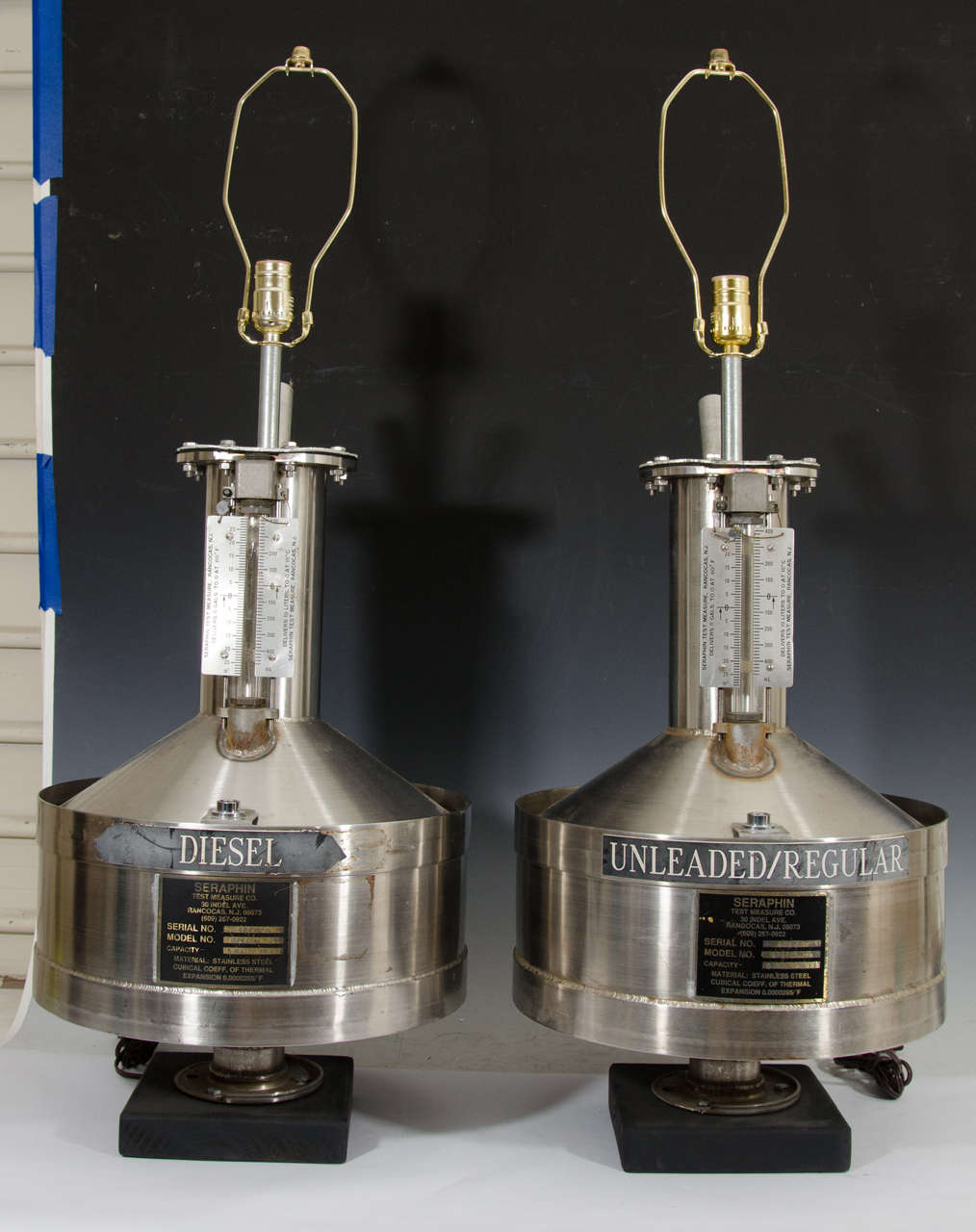 A pair of vintage Industrial style table lamps, crafted, circa 1970s from stainless steel gas tanks, with original Seraphin Test Measure Co. labels; one is diesel, the other is unleaded or regular. Good vintage condition with age appropriate patina,