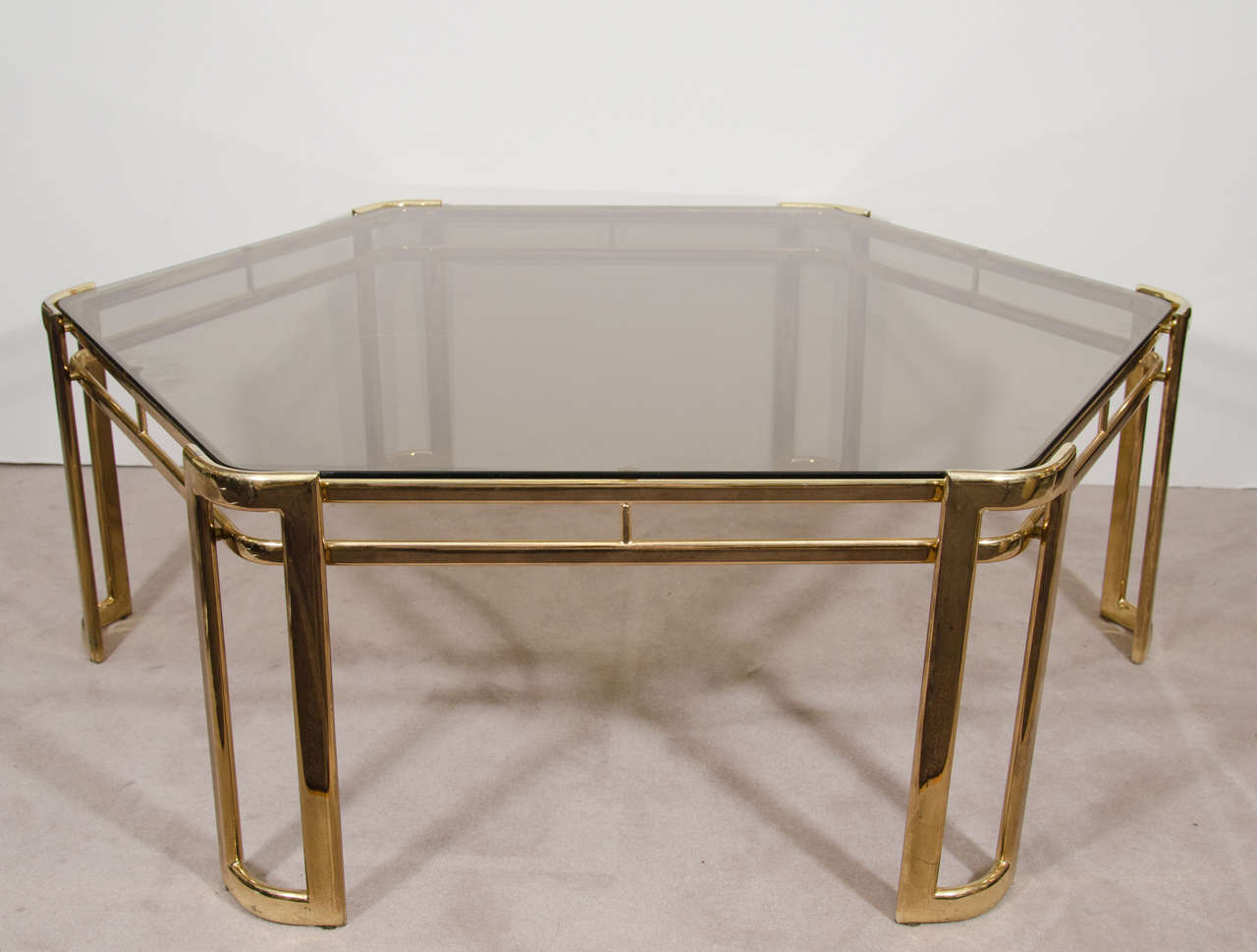 A vintage brass-plated and smoked glass hexagonal coffee or cocktail table. 

Good vintage condition with age appropriate wear and patina. One faint scratch to glass.