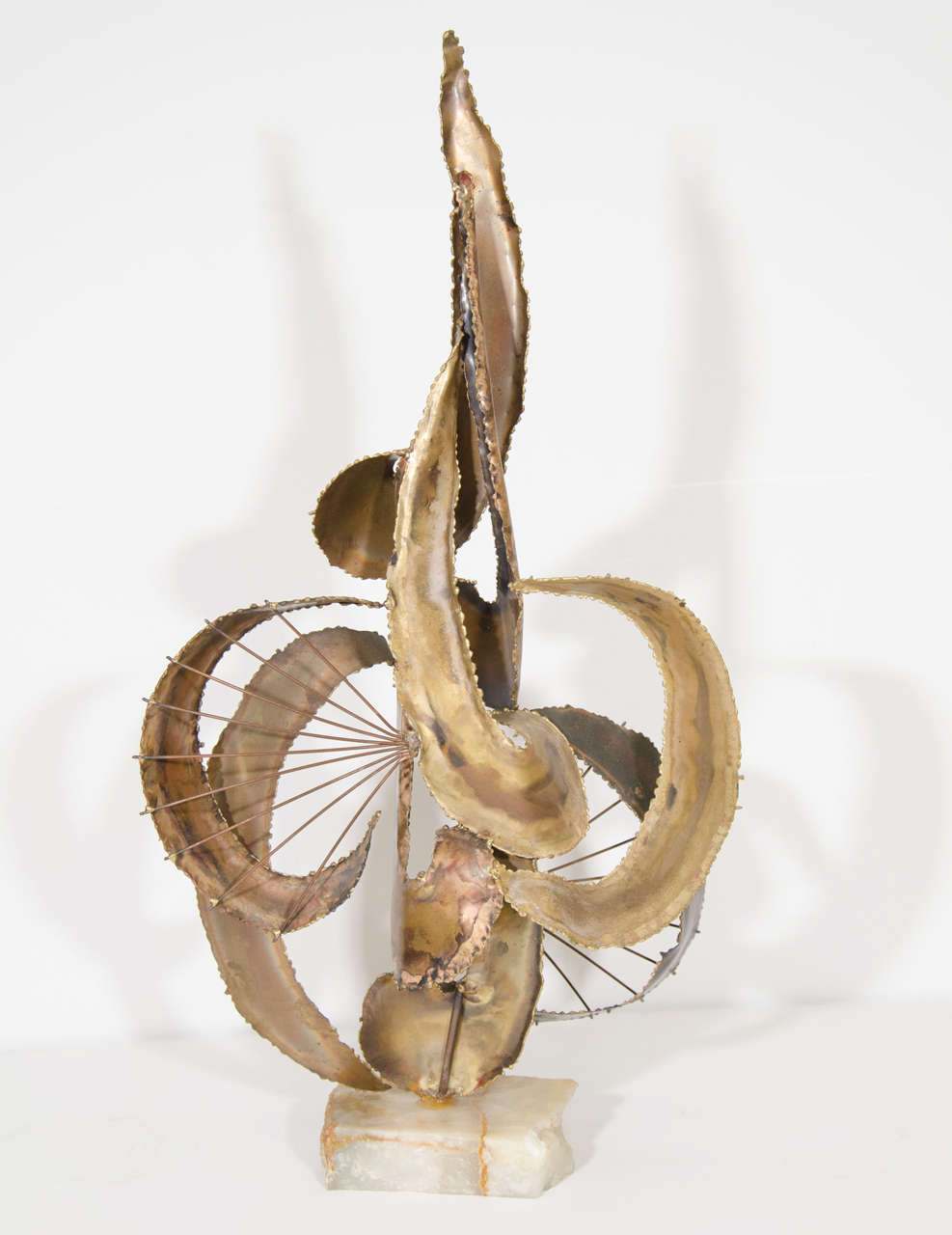 A vintage mixed metal sculpture in the style of Curtis Jere with alabaster base.