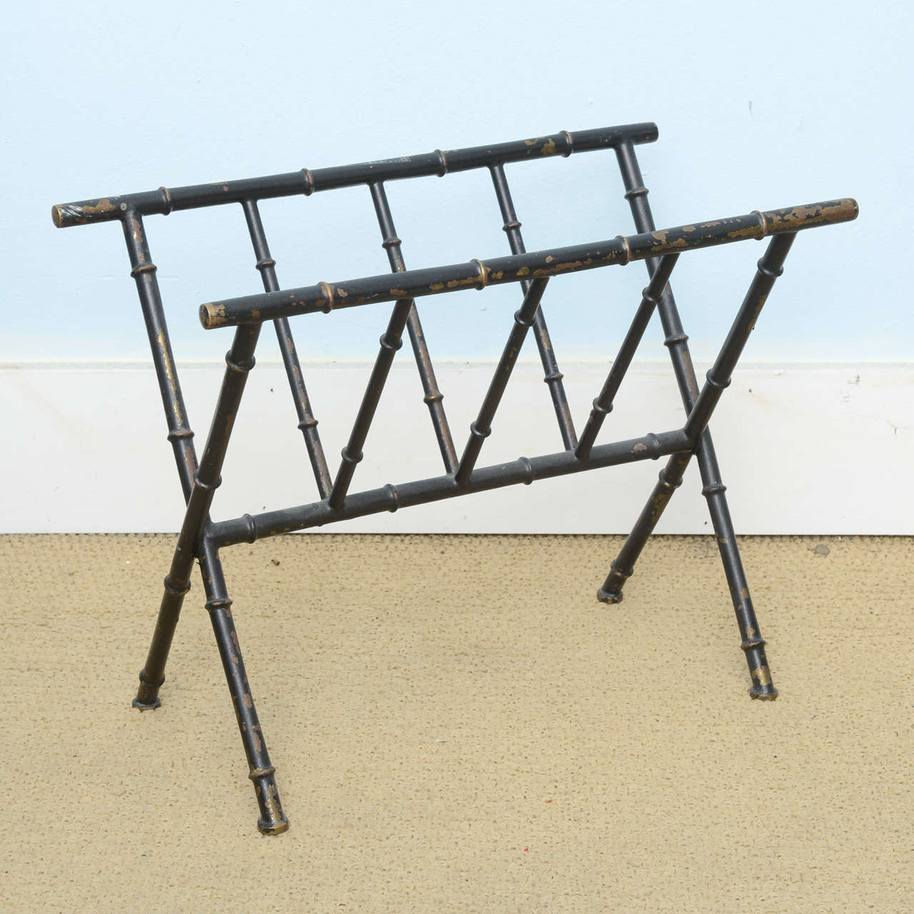 All original condition Maison Jensen magazine rack. This piece was featured in the Nov 2014 issue of architectural digest and stated that it is Maison Jansen. It is in all original condition brass painted black with years of wear .A very chic way of