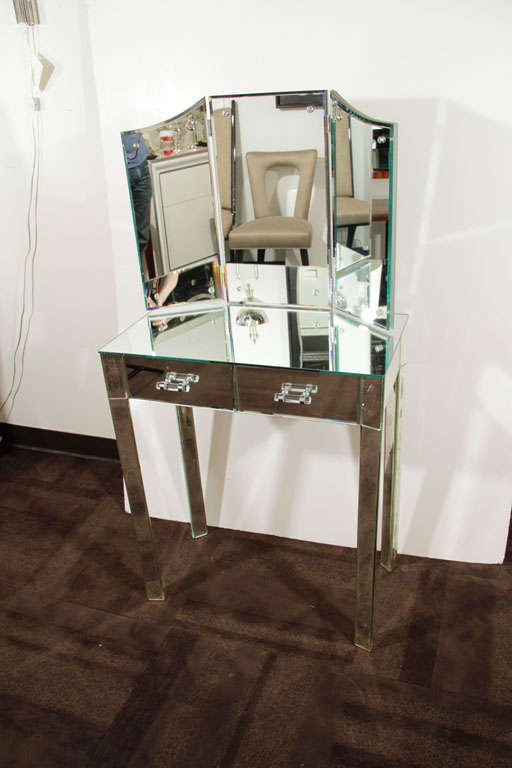 Beautiful mirrored vanity fitted <br />
with two drawers with glass pull<br />
details, and with a table top <br />
trifold dressing mirror. The <br />
reverse side of the vanity and<br />
trifold mirror is finished in<br />
silver leaf. Also