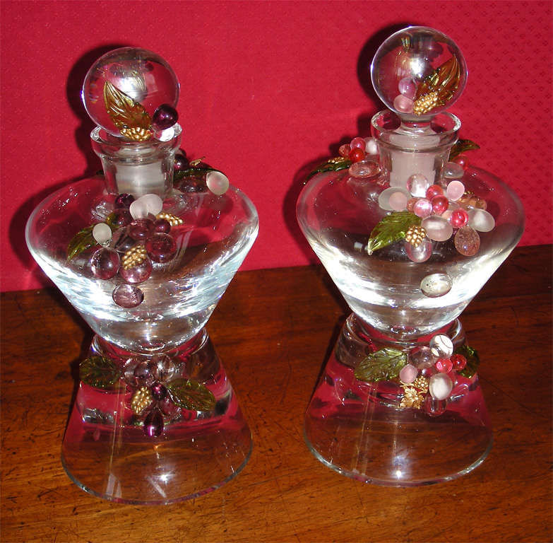 Two 1997 decorated bottles by Frédérique Lombard Morel, in crystal, glass, glass paste and metal elements gilt in a 24 karat solution.