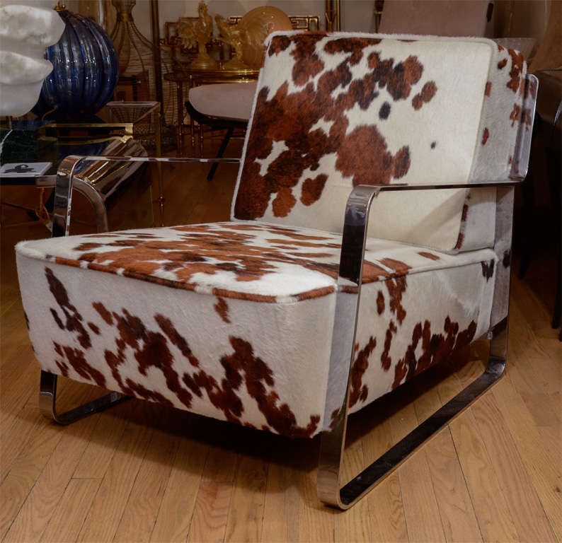 Pair of chrome low slung arm chairs with haircalf upholstered cushions