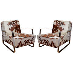 Pair of chrome low slung arm chairs with haircalf upholstered cushions