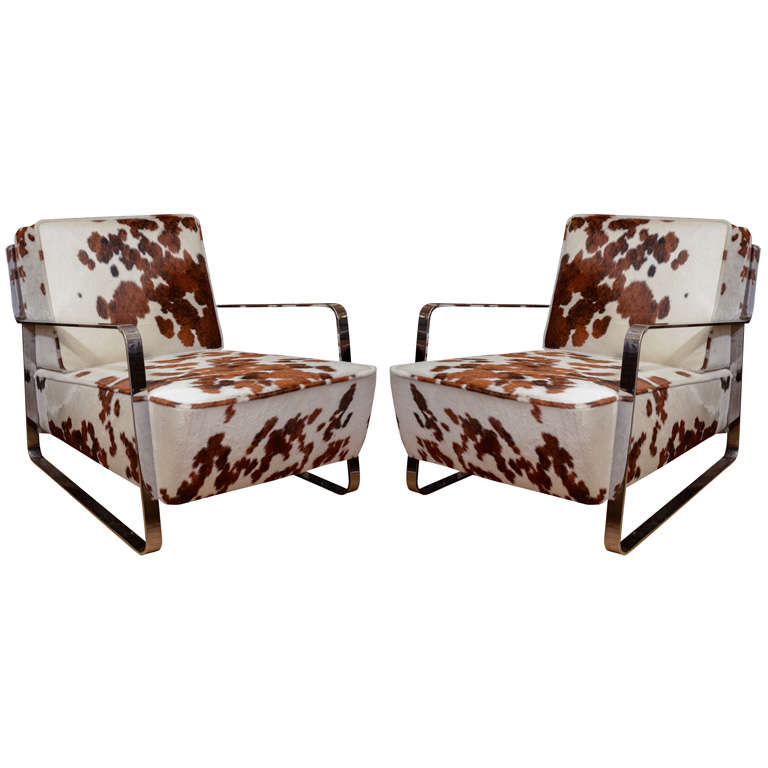 Pair of chrome low slung arm chairs with haircalf upholstered cushions