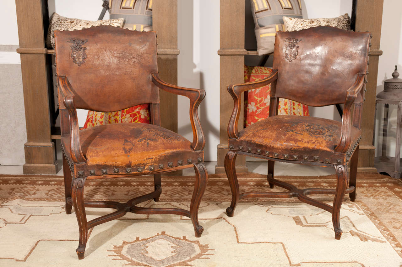 Pair of French Country style oak armchairs in original leather .
Embossed and studded.
Restored from within .. new fabric on outside back