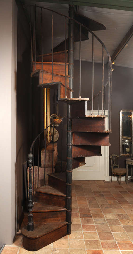 Oak spiral staircase with iron balusters and railing. French, around 1890. 