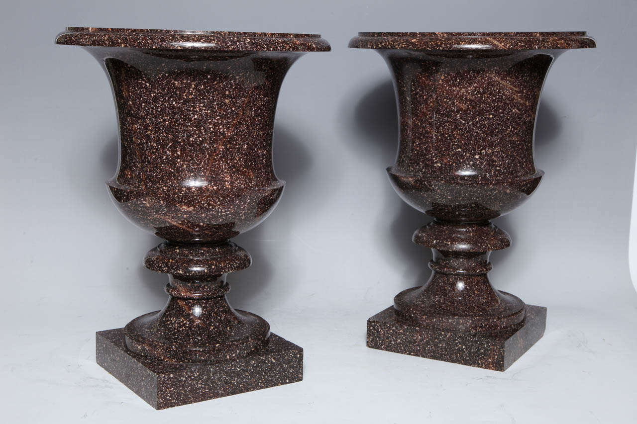 A monumental pair of neoclassical period, Swedish Porphyry Campagna shaped vases, circa 1810. These magnificent handcrafted urns are carved from the uniquely Swedish Porphyry stone, rest on square plinths. Purchased from Didier Aaron in Paris by
