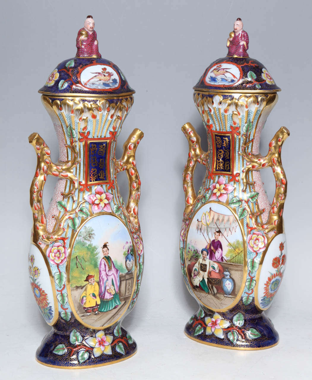 A Very unusual and fine pair of antique vases by French Jacob Petit. Chinosseri decorated, with covers and delicately crafted handles. Each vase depicts the Emperor and Empress in the Royal Garden, and a figure of an Imperial guard seated on the top