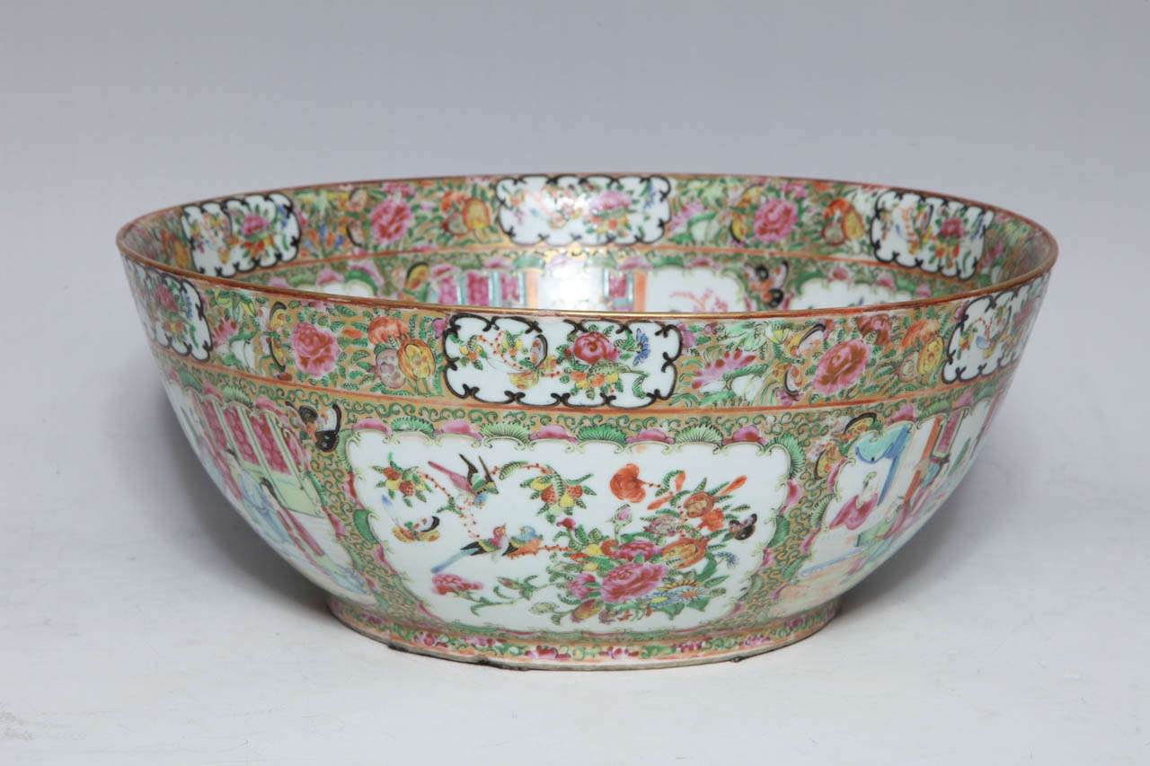 A massive 19th century enameled Chinese export porcelain 'Canton Famille Rose' punchbowl. Enameled with panels of scholars beneath a gilt band of butterflies, birds and flowers. The interior is decorated with two warriors sparring and panels of