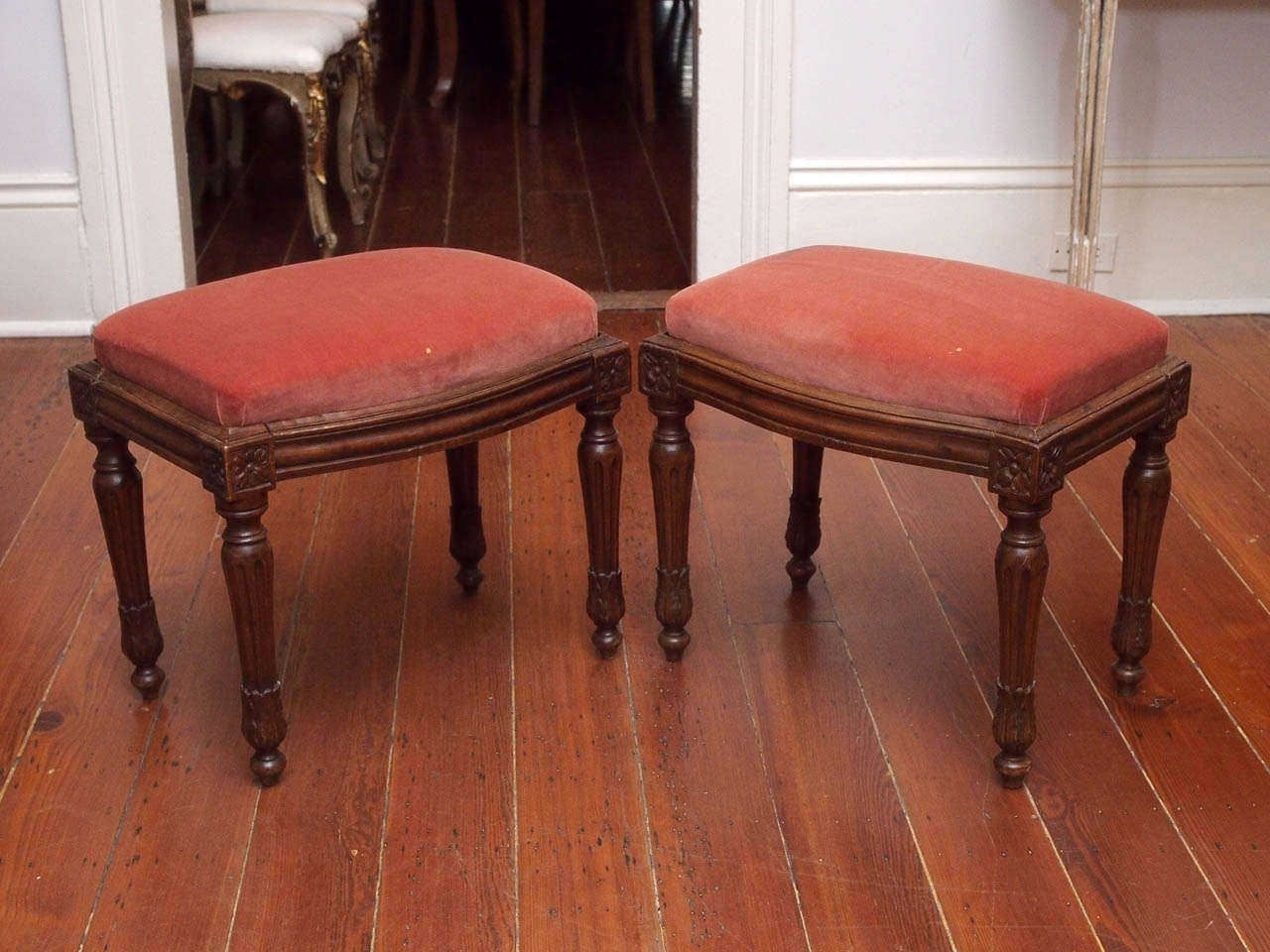 A pair of well carved walnut stools, the seats lifting out of tops molded, the sides bowed, and resting on fluted, shaped legs ending in water leaves on small toupie feet.
