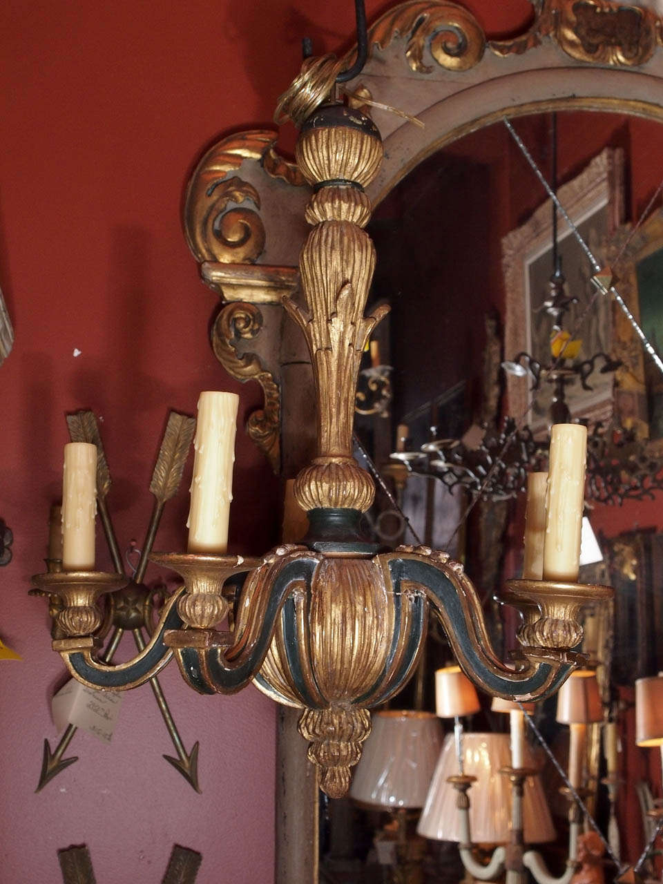 A midcentury carved wood gold painted chandelier with dark accents.