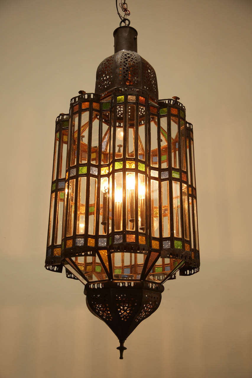 Large Moroccan Moorish chandelier in clear glass  with some colored glass. Delicately handcrafted in Morocco.
Moroccan light fixture rewired with a cluster of 4 lights.
Comes with chains and canopy, chains could be adjusted to your