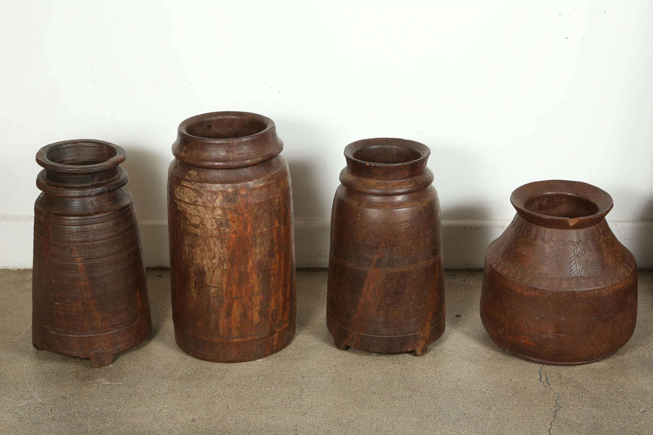 Set of 4 wooden rice grinders from Rajasthan, south East India.
These wooden vessels, mortars are made from one solid piece of wood that has been hollowed after years of use to grind rice.
They are nicely carved and have a great antique