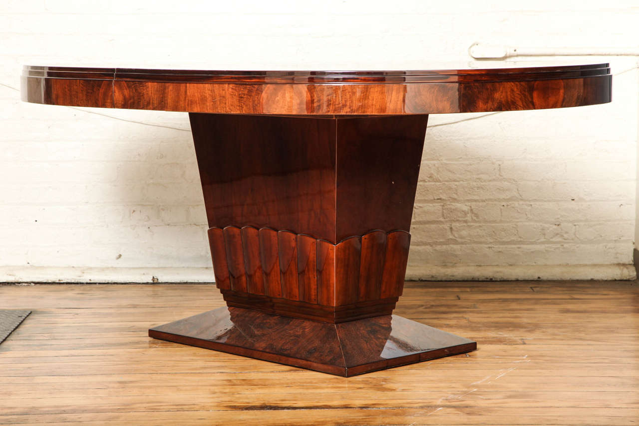 Fabulous oval Art Deco dining table on pedestal and floating base. Book matched walnut root. Has one finished matched extension (19.75