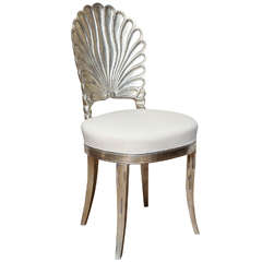An Italian shell back carved and silver leafed chair
