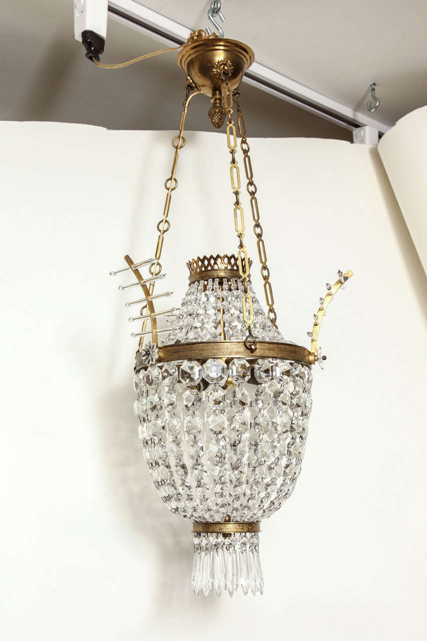 A French Louis XVI style pendant fixture with vase shaped body suspended from three lengths of chain and canopy. The frame draped with faceted beads of graduating size concealing three candelabrum sockets. Maximum wattage 60 watts per socket. The