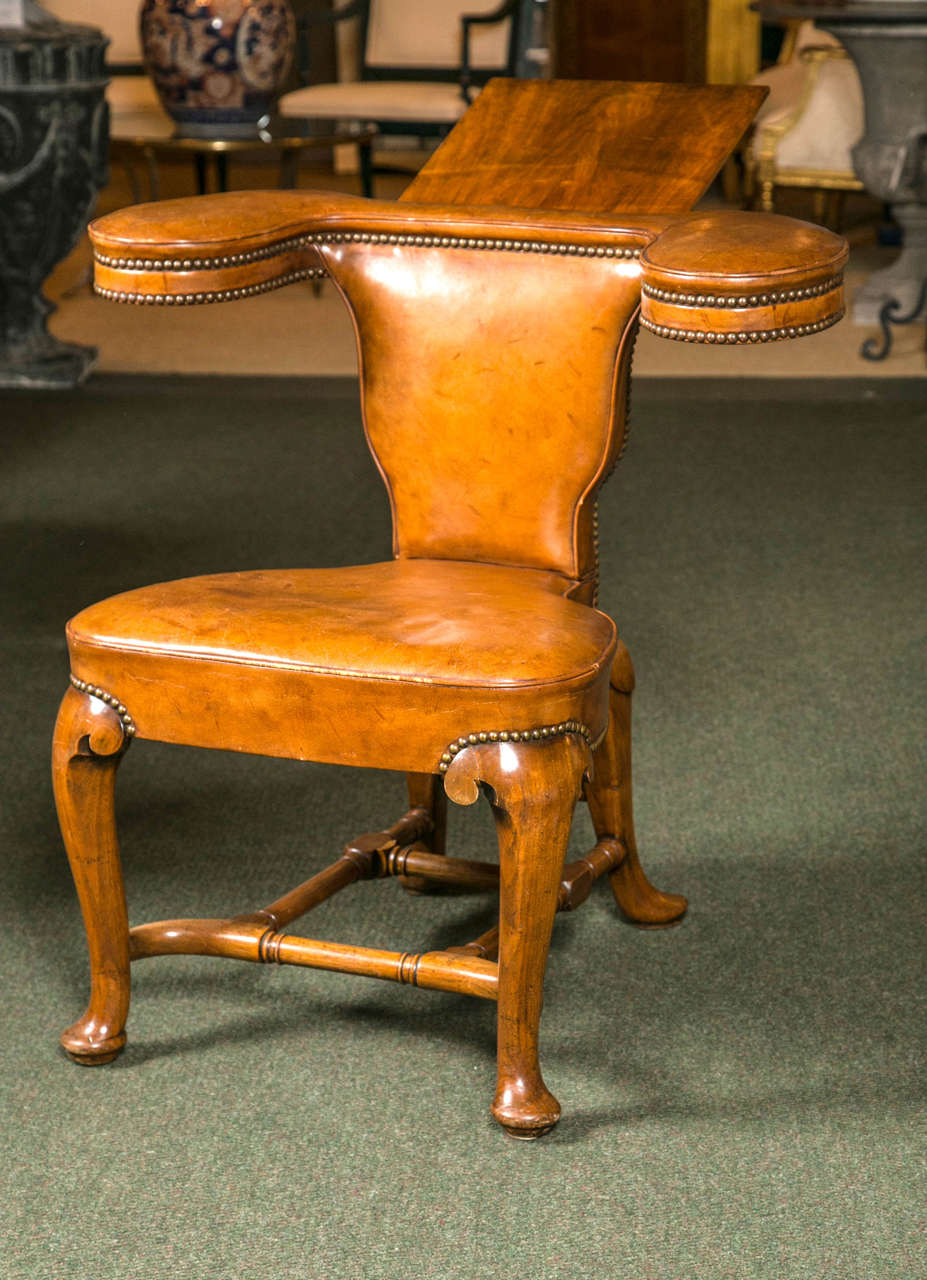 A 19th century English Georgian leather reading chair.

Dating to the late-Georgian period, this reading chair finds its origins in England. Created out of wood and leather, this type of chair was used for two different purposes; it can either use