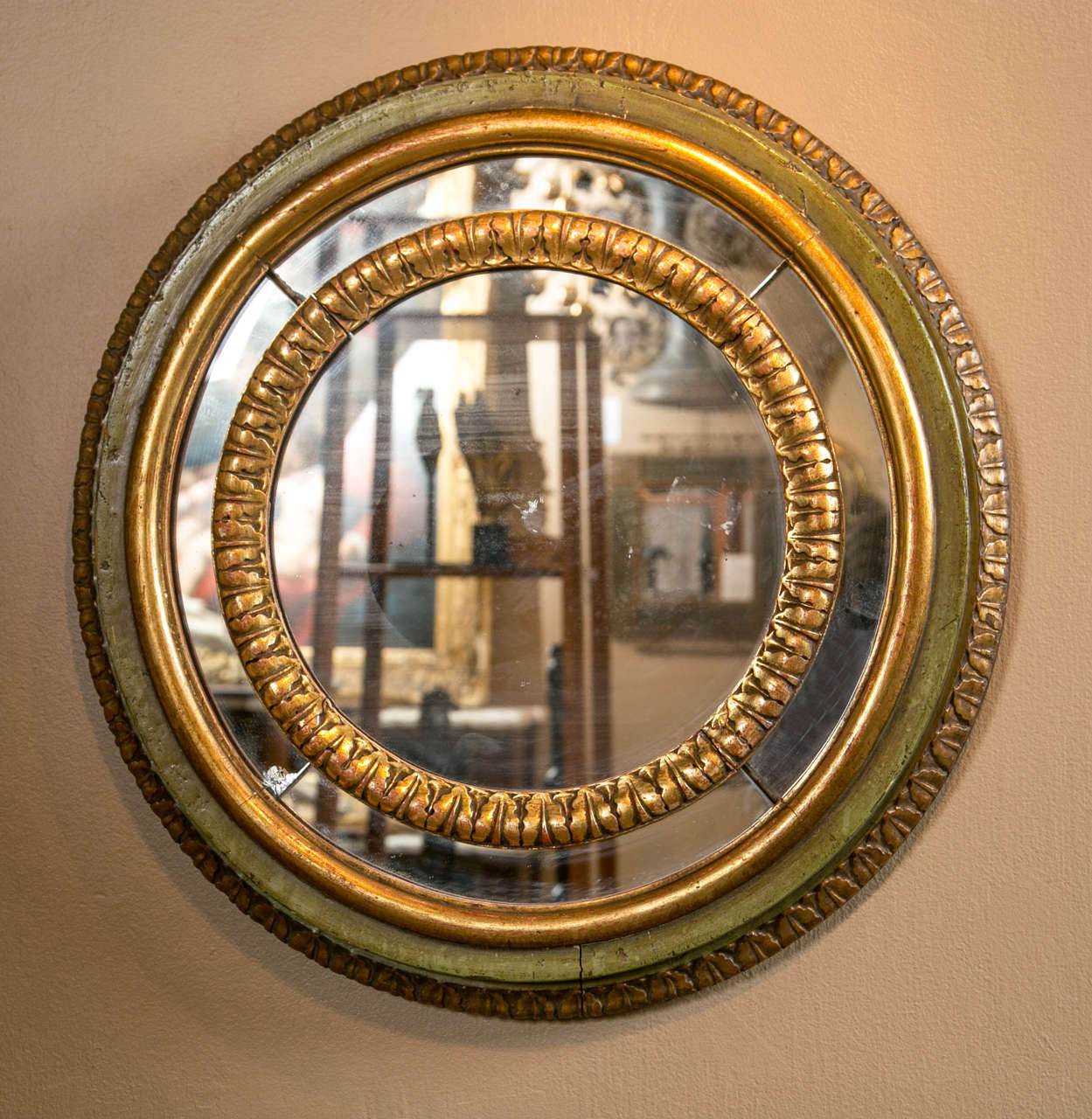 A pair of 19th Century gesso and gilt round mirrors with green paint and acanthus carved outer surround.