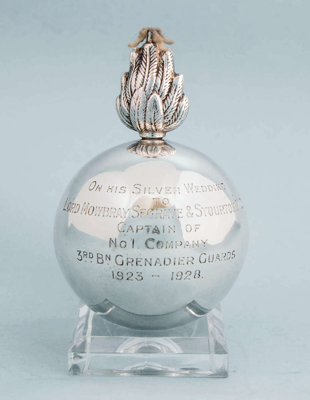 Interesting grenade-shaped sterling silver table cigar lighter,
Birmingham, 1932.

Engraved: 'On his silver wedding to Lord Mowbray, Segrave and Stourton, M C Captain of No 1 Company 3rd Bn Grenadier Guards 1923-1928.'

This lighter of military