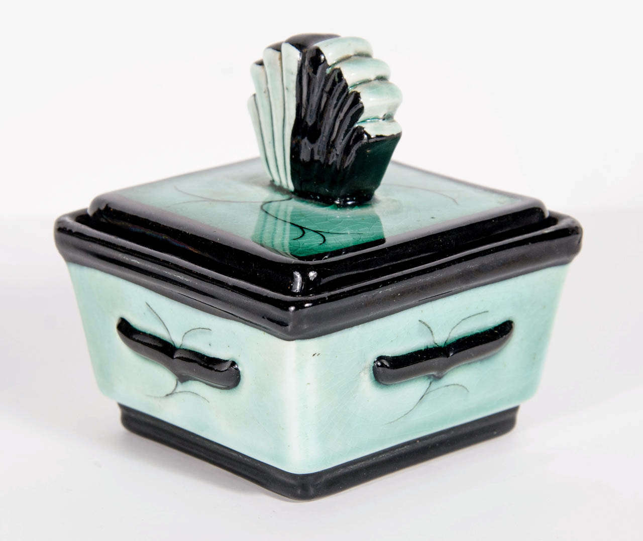 This exquisite square box with fan style lid by Ilse Claussen of Sweden in aqua blue green glaze has stylized hand painted Art Deco detailing. Signed on the bottom with Ilse Claussens initials as well as the Rorstrand hallmark. Ilse Claussen worked