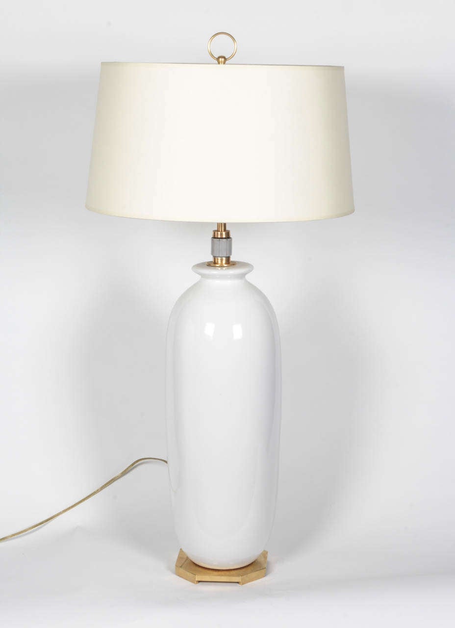 A finely made white porcelain table lamp by Hanson. USA, crca 1960. Signed. 
Features original polished brass hardware and base with new wiring. 
Takes three standard bulbs, 60 watts max each.