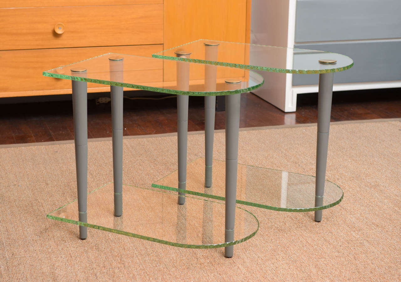 Pair of Art Deco end tables with two-tier chisel edge glass shelves and newly lacquered legs.