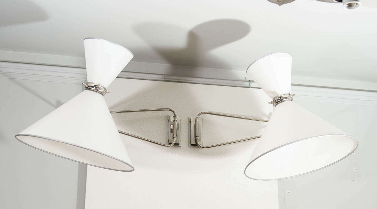 Pair of sconces by Lunel in polished nickel. Articulated double shades with two bulbs.