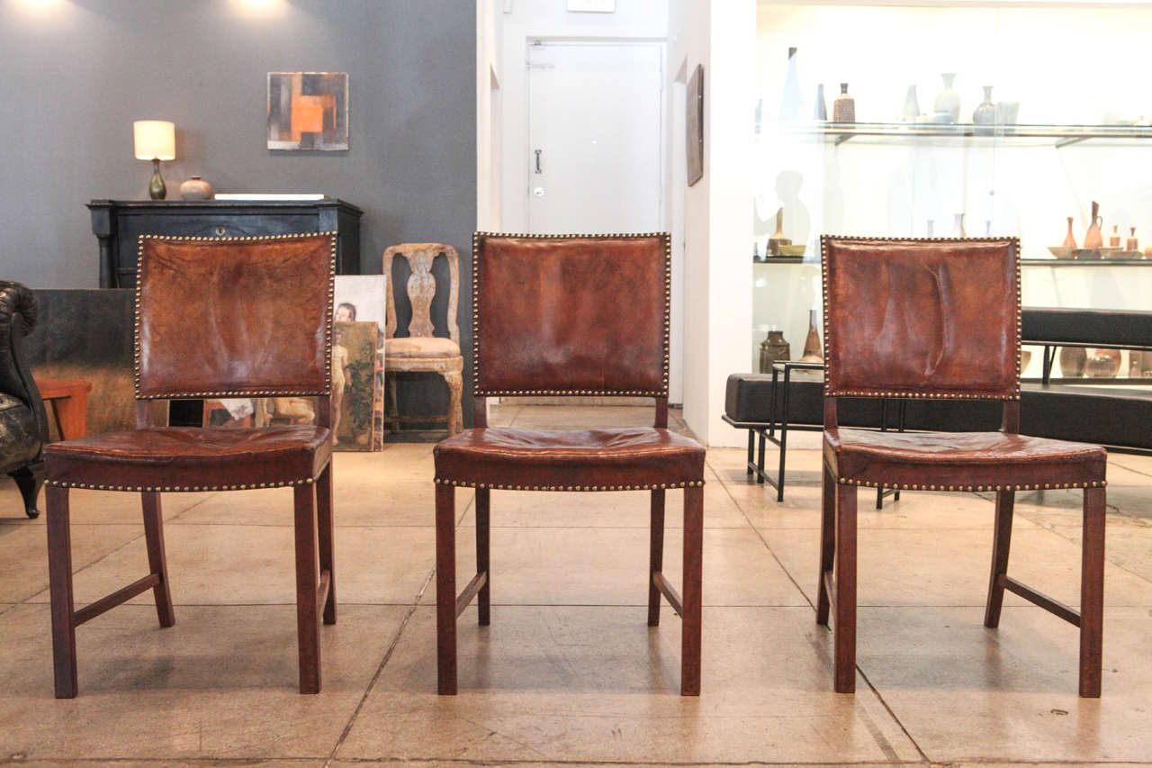 A set of six darkened cognac dining chairs with original mahogany frames and brass nailheads.

Sold only as set.