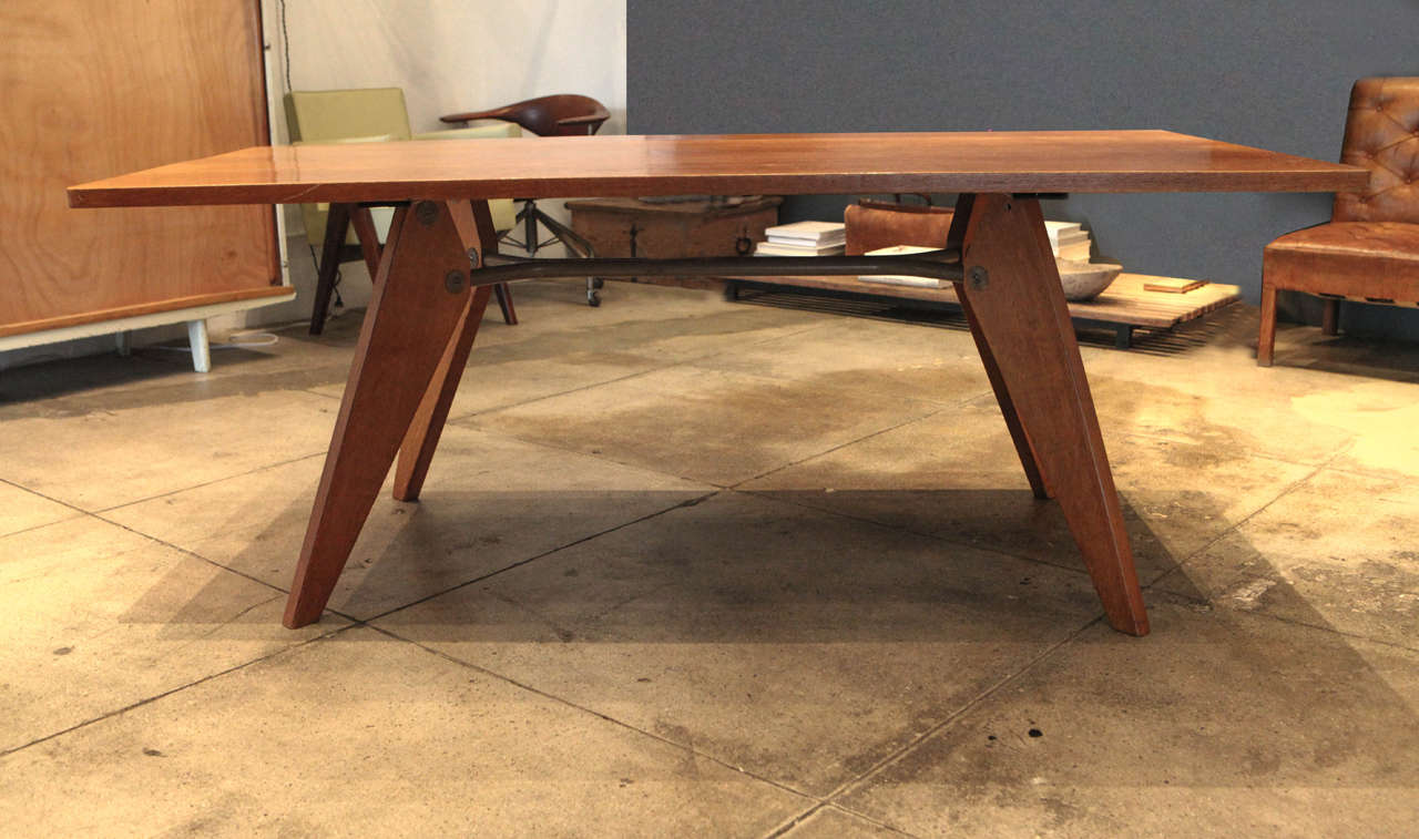 A Jean Prouve dining table in French oak and enameled steel frame.