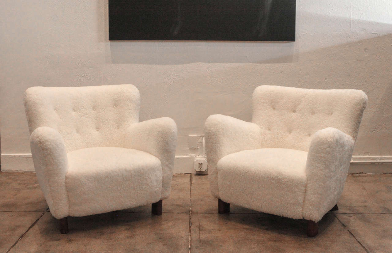 Fritz Hansen's sheepskin and beech frame lounge chairs.
Sold only as a pair.