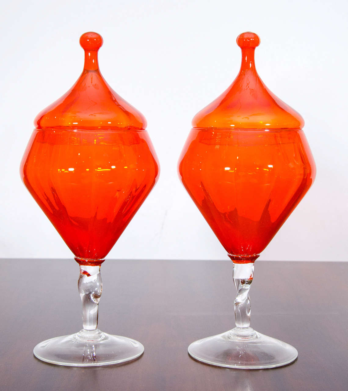 Beautiful pair of apothecary jars by Empoli in a striking orange with clear glass twisted stems. Please contact for location.