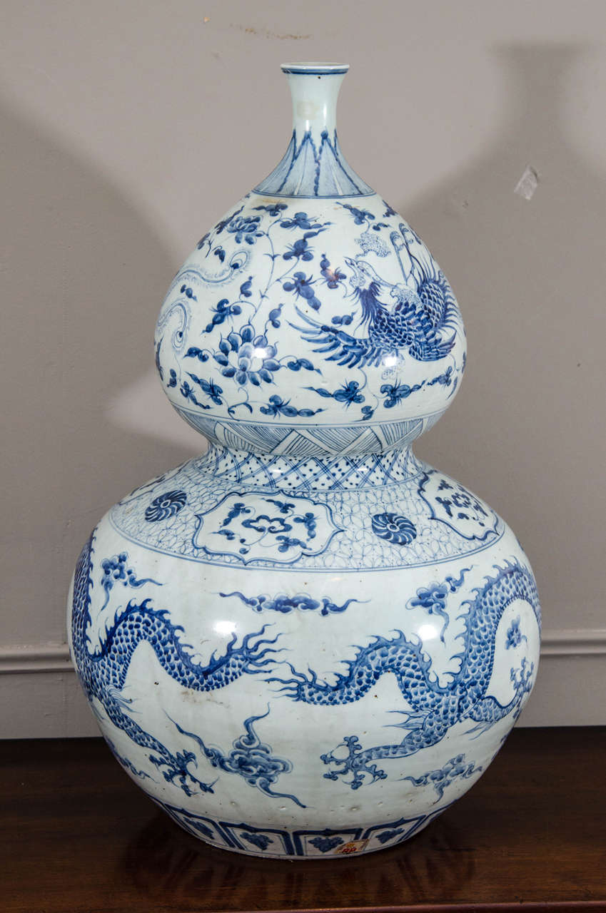 This large Chinese porcelain calabash vase is decorated with a dragon-and-fenghuang (Chinese phoenix) design.