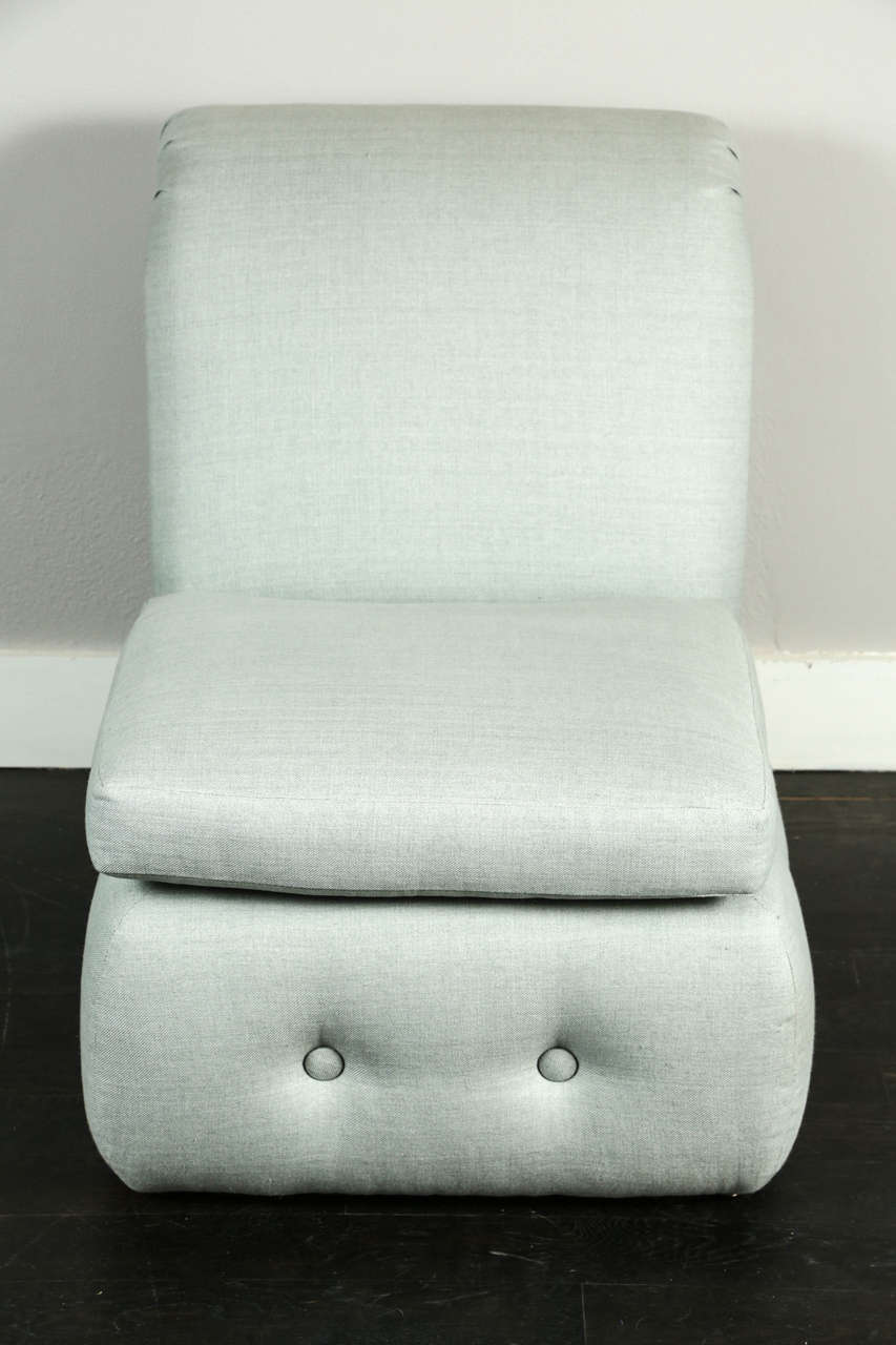 Pair of slipper chairs with rolled back and tufted base. Upholstered in blue grey linen.