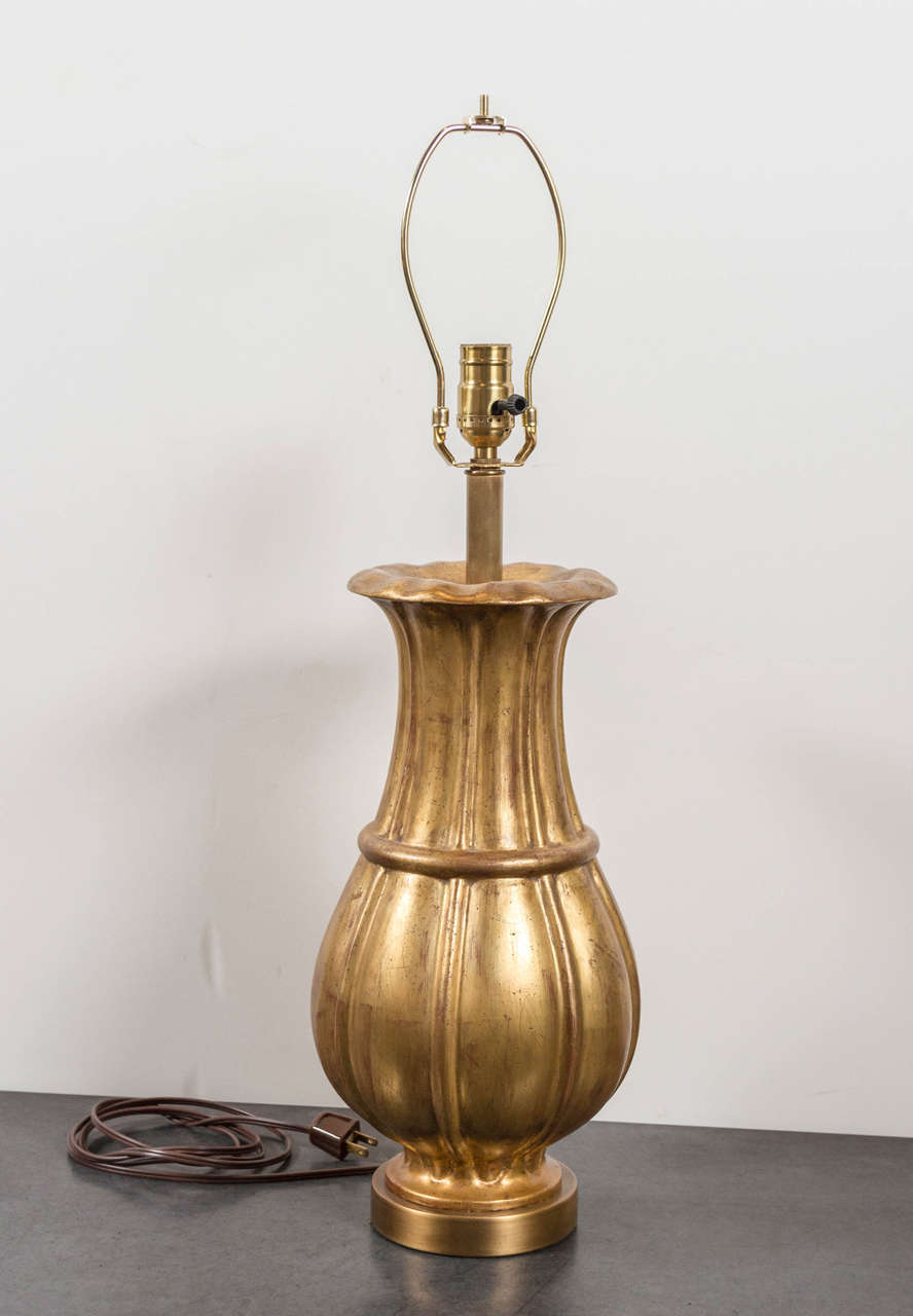 Gilded heavy plaster urn table lamp. Water gilded gathered acanthus leaf form. Recently wired.